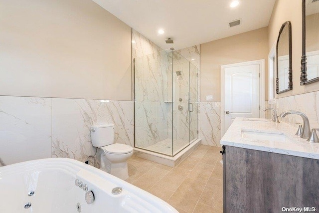 full bathroom with tile patterned flooring, shower with separate bathtub, toilet, vanity, and tile walls