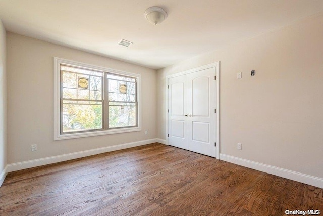 unfurnished bedroom featuring wood-type flooring and a closet