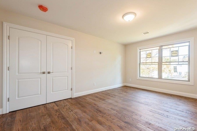 unfurnished bedroom featuring hardwood / wood-style flooring and a closet