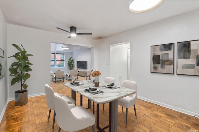 dining room with ceiling fan and parquet floors