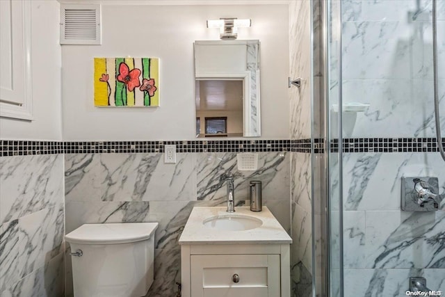 bathroom featuring an enclosed shower, vanity, toilet, and tile walls