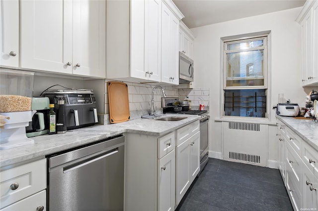 kitchen featuring tasteful backsplash, sink, white cabinets, and appliances with stainless steel finishes