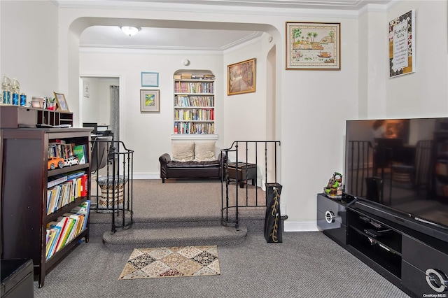 living area featuring crown molding and carpet