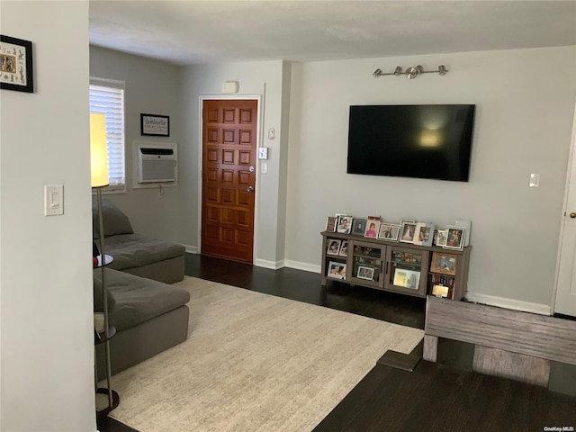 living room featuring dark wood-type flooring and a wall unit AC