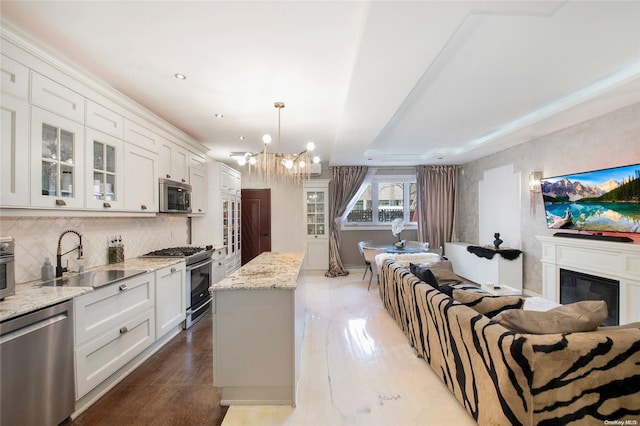 kitchen with white cabinets, backsplash, sink, and appliances with stainless steel finishes