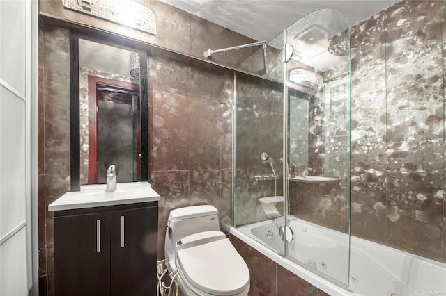 full bathroom featuring vanity, tiled shower / bath combo, toilet, and tile walls