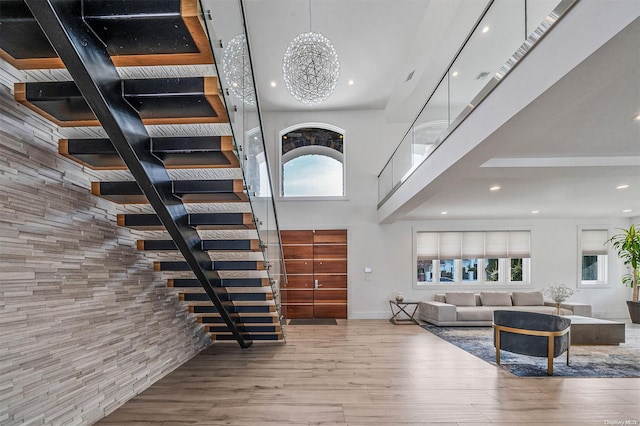 interior space featuring wood-type flooring, a towering ceiling, and plenty of natural light