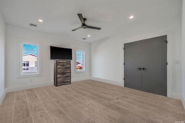 unfurnished bedroom featuring ceiling fan, a closet, and light hardwood / wood-style floors