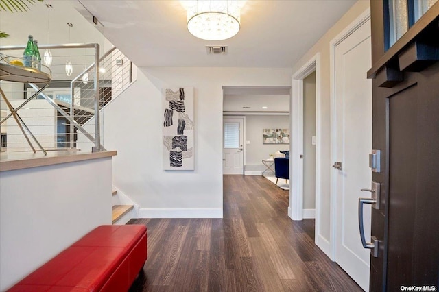 hall featuring a chandelier and dark hardwood / wood-style flooring