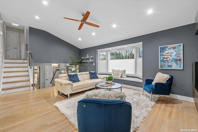 living room with ceiling fan, hardwood / wood-style floors, and vaulted ceiling