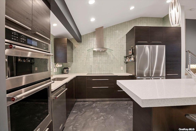 kitchen with decorative backsplash, appliances with stainless steel finishes, wall chimney exhaust hood, sink, and lofted ceiling