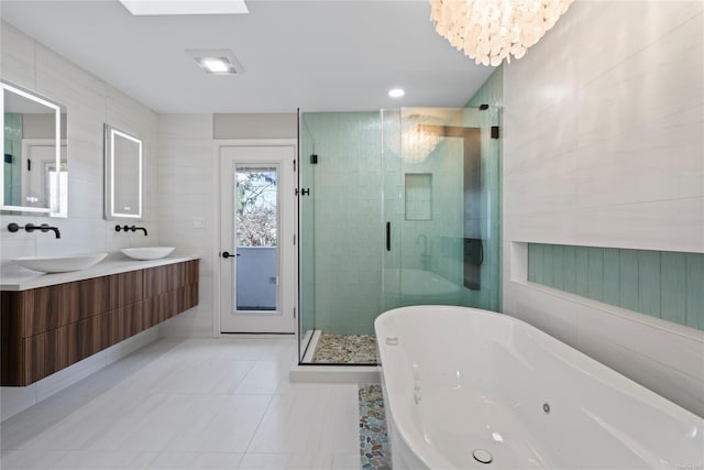 bathroom featuring tile patterned floors, vanity, tile walls, independent shower and bath, and a chandelier