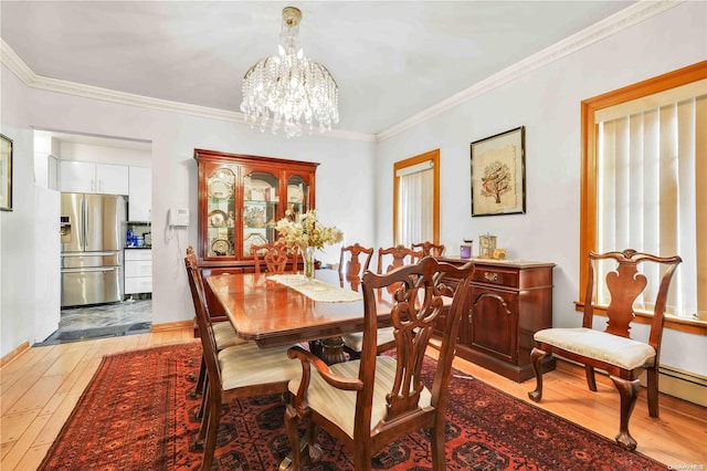 dining room with light wood-type flooring, crown molding, and an inviting chandelier