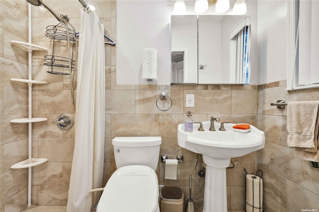 bathroom with curtained shower, tile walls, and toilet