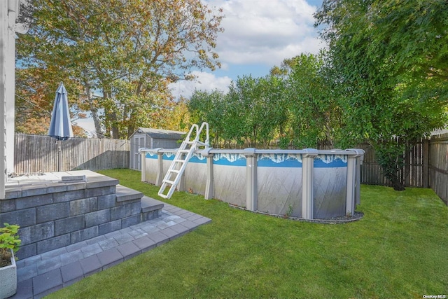 view of yard featuring a fenced in pool and a storage shed