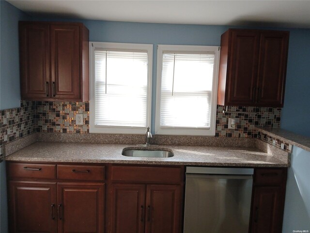 kitchen featuring stainless steel dishwasher, decorative backsplash, and sink