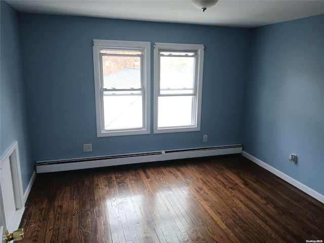 spare room with dark hardwood / wood-style flooring and a baseboard radiator