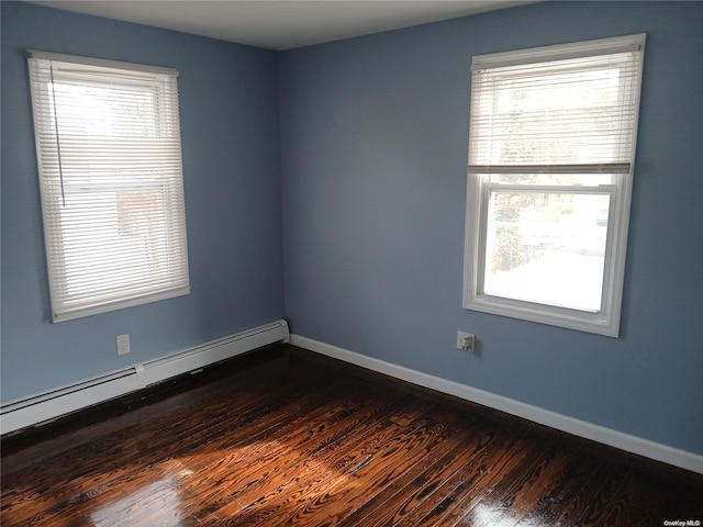 empty room with dark hardwood / wood-style flooring and a baseboard radiator