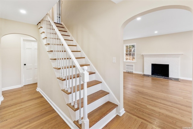 stairs featuring a fireplace and hardwood / wood-style floors