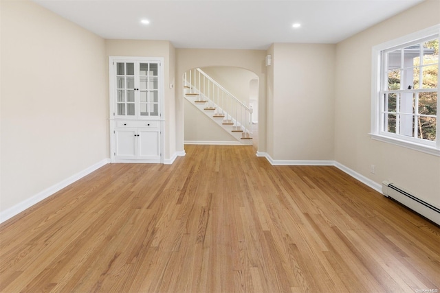 unfurnished room featuring light hardwood / wood-style flooring and a baseboard radiator