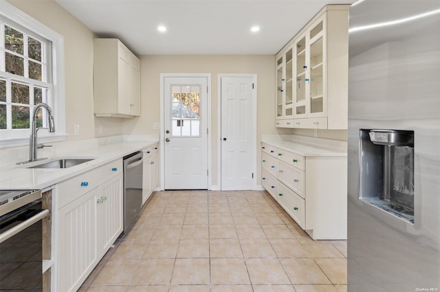 kitchen with a healthy amount of sunlight, light tile patterned floors, sink, and stainless steel appliances