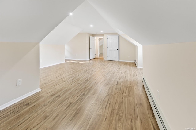 additional living space with light hardwood / wood-style floors, vaulted ceiling, and a baseboard radiator