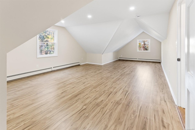 additional living space featuring light wood-type flooring, a baseboard radiator, and lofted ceiling