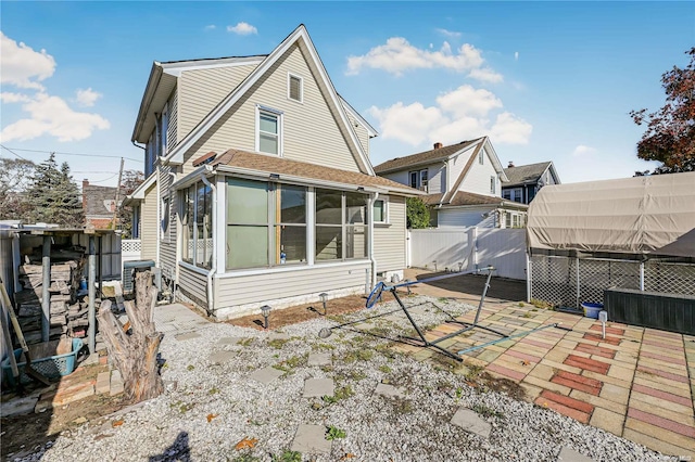 back of property featuring a patio area and a sunroom