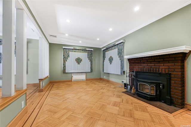 unfurnished living room with a wood stove, crown molding, radiator, and light parquet floors