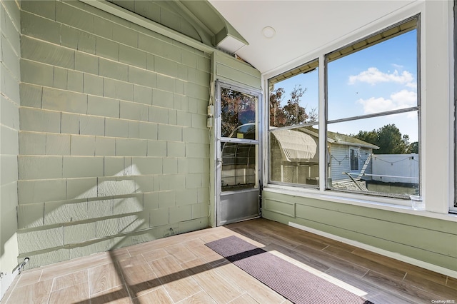 unfurnished sunroom with lofted ceiling