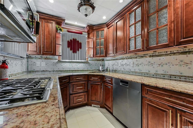 kitchen featuring backsplash, sink, light stone countertops, appliances with stainless steel finishes, and light tile patterned flooring