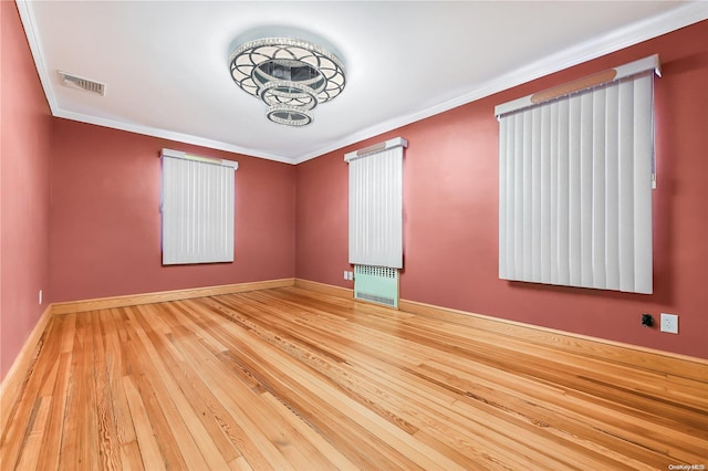 empty room featuring crown molding and hardwood / wood-style floors