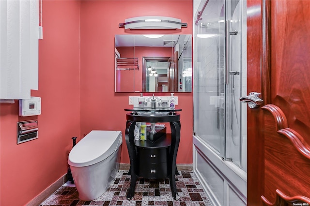 bathroom with bath / shower combo with glass door and toilet