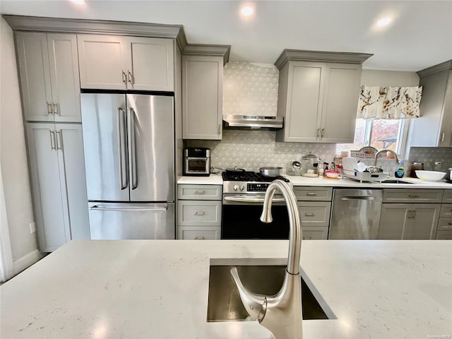 kitchen featuring backsplash, gray cabinets, sink, and stainless steel appliances