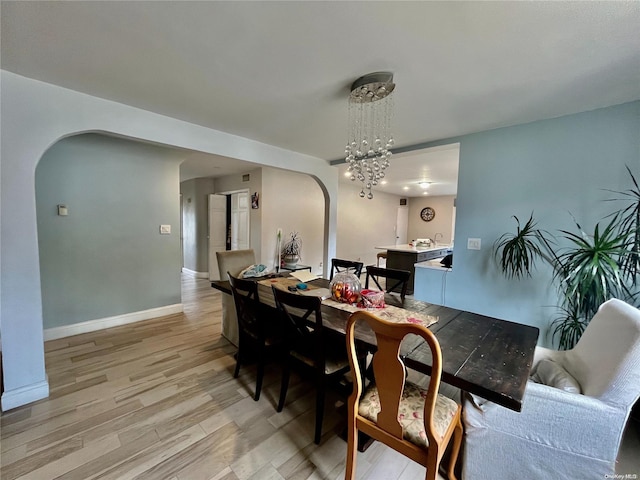 dining room with a notable chandelier and light wood-type flooring