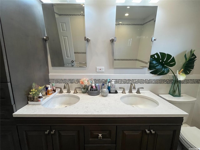 bathroom featuring decorative backsplash, vanity, and toilet