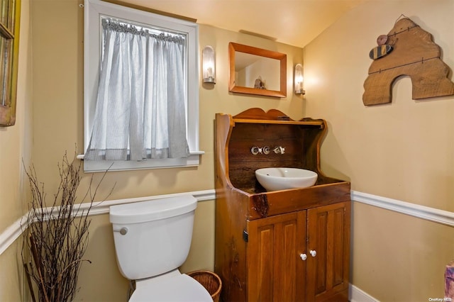 bathroom featuring vanity, toilet, and vaulted ceiling