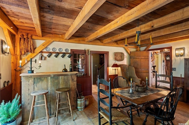 dining room with beam ceiling, wood-type flooring, and wood ceiling