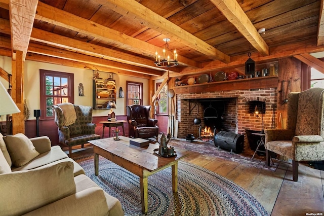 living room with beam ceiling, hardwood / wood-style flooring, a brick fireplace, and wood ceiling