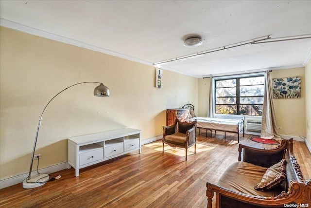 living area featuring ornamental molding, a wall mounted air conditioner, and hardwood / wood-style flooring