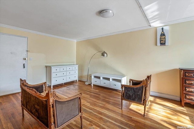 sitting room with hardwood / wood-style floors and crown molding