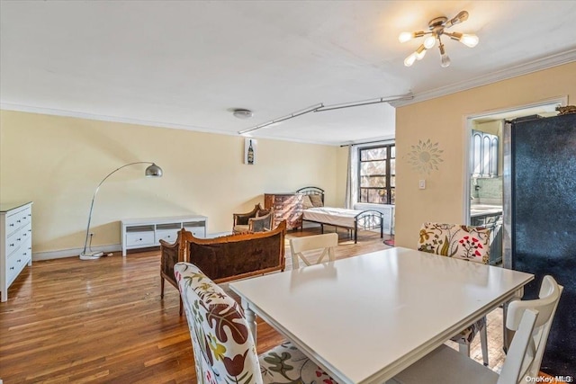 dining room with hardwood / wood-style floors, a notable chandelier, and ornamental molding