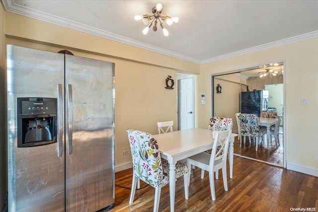 dining space with hardwood / wood-style flooring, crown molding, and an inviting chandelier