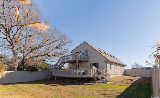 rear view of property featuring a lawn and a wooden deck