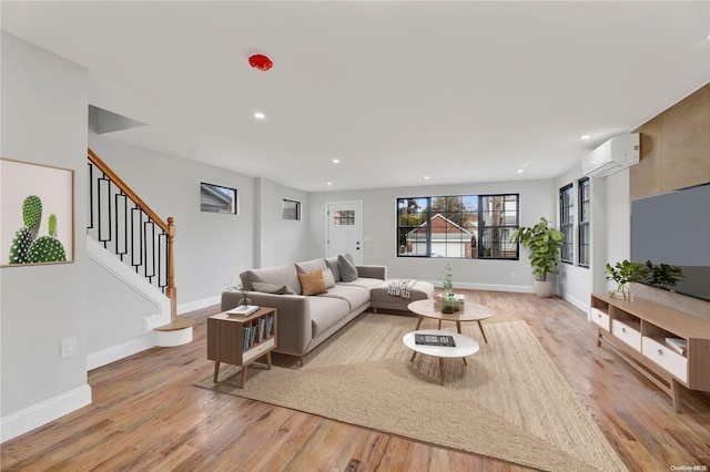 living room featuring light hardwood / wood-style floors and an AC wall unit