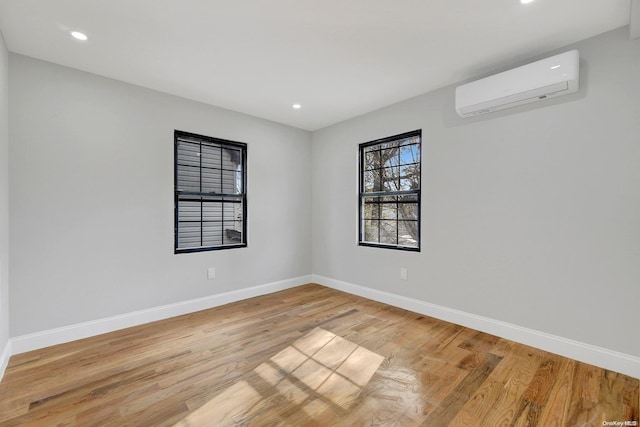 spare room with light hardwood / wood-style floors and a wall mounted AC