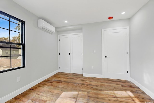 interior space with light hardwood / wood-style floors and a wall mounted AC