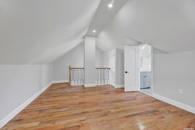 bonus room featuring lofted ceiling and light wood-type flooring