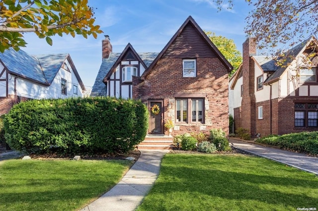 tudor-style house featuring a front lawn