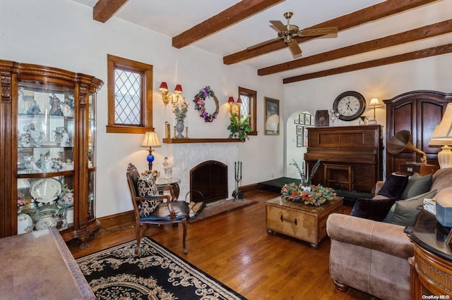 living room featuring hardwood / wood-style floors, ceiling fan, and beam ceiling